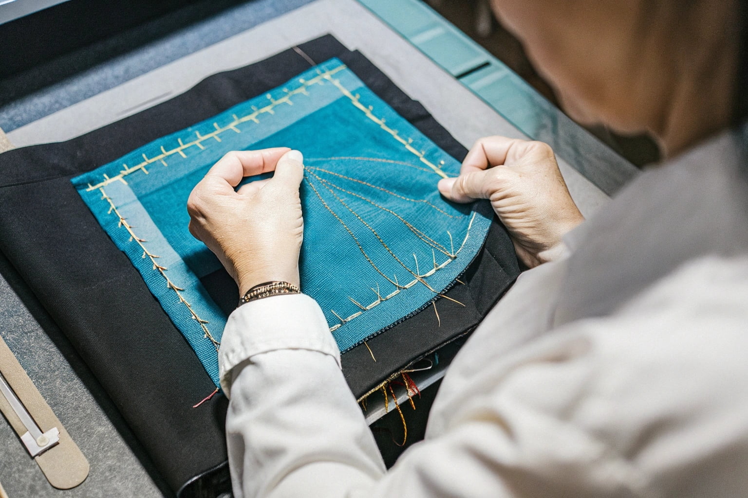 A person inspecting a hand-embroidered fabric closely